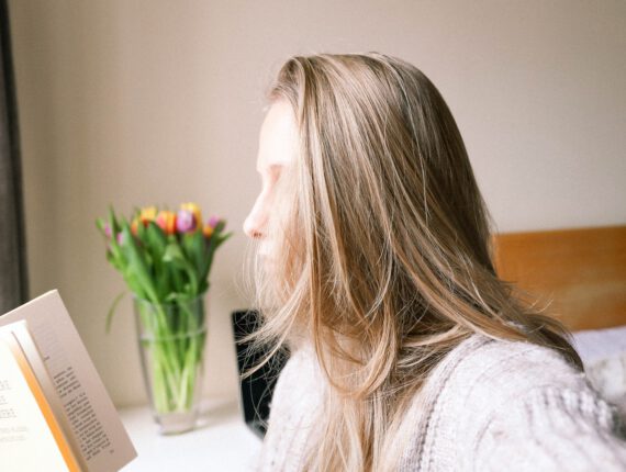 Woman with light hair is reading a book